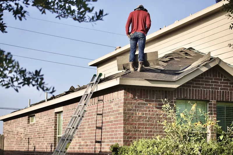 Professional roofer working on a residential roof in Martins Addition